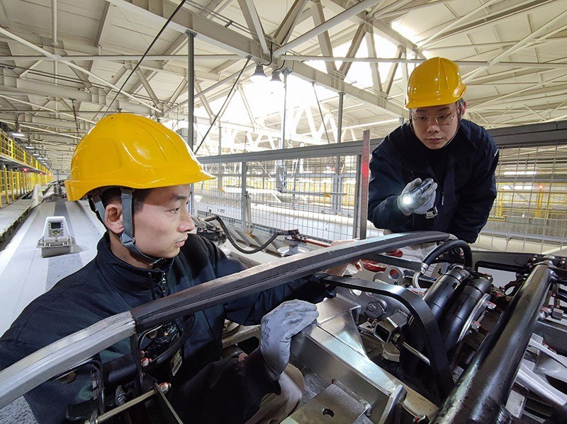 除夕當(dāng)天，動車組機(jī)械師正在測量動車組受電弓碳滑板厚度。王子俊 攝