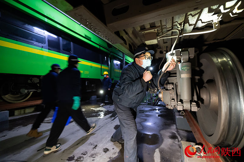 1月26日，西安客車車輛段，鐵路檢修“小哥”正在檢查動(dòng)力集中型動(dòng)車組走行部件。劉翔攝