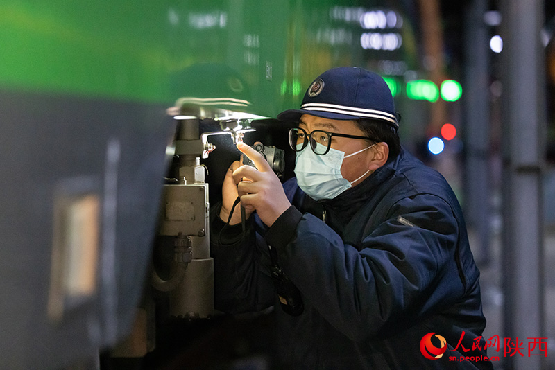 1月26日，西安客車車輛段，鐵路檢修“小哥”正在檢查動力集中型動車組注水口保證旅客正常用水。劉翔攝