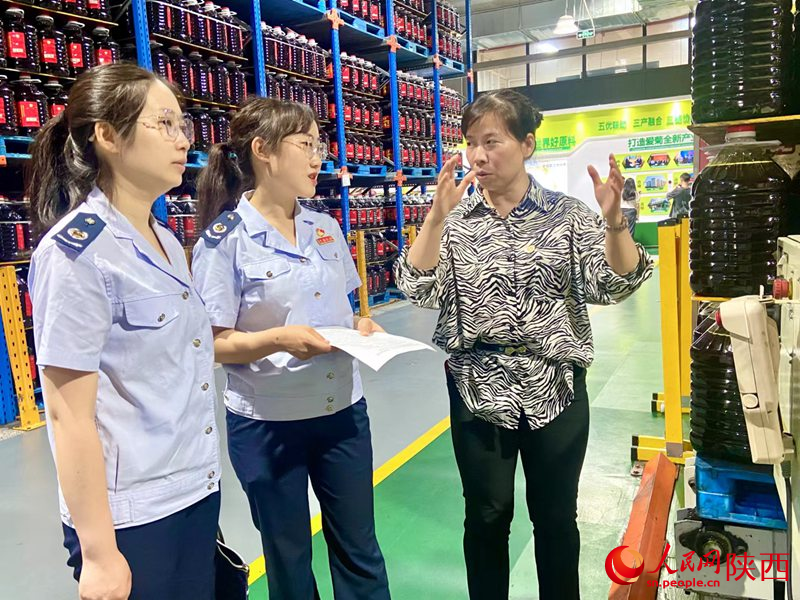 西安市稅務(wù)局青年干部道愛菊糧油集團(tuán)有限公司送政策。人民網(wǎng)記者王晴垣 攝