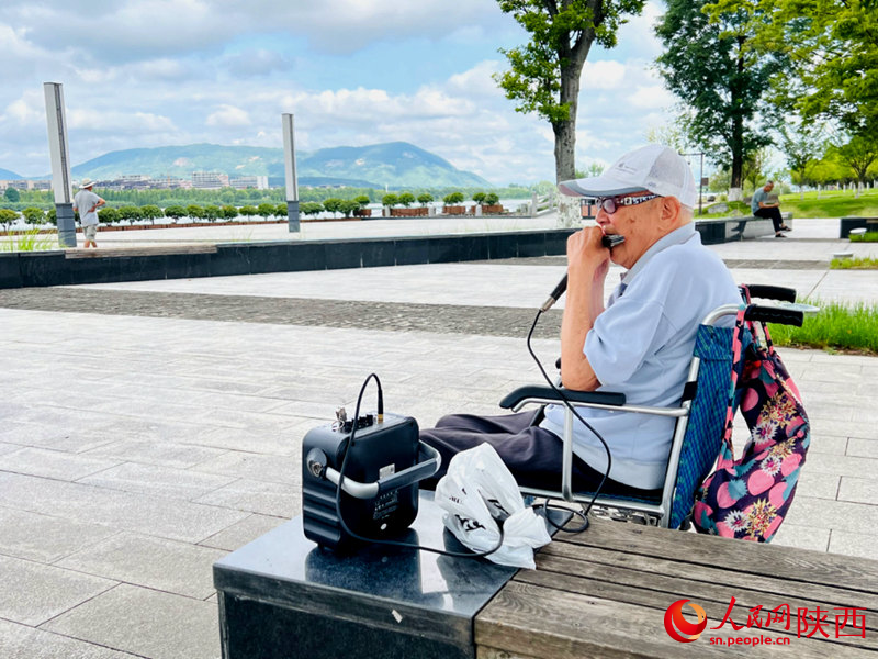 94歲的張大爺每天都會到天漢濕地公園憩息吹口琴。人民網(wǎng)記者 孫挺攝