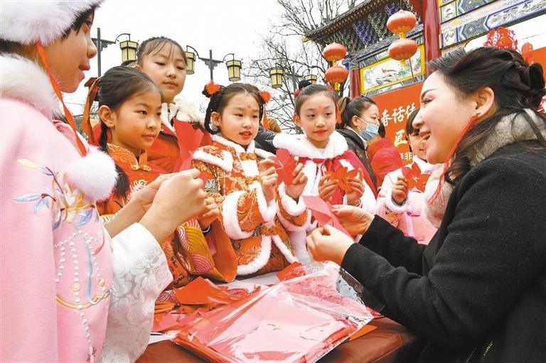 1月20日，西安永興坊·陜西非遺文化特色街區(qū)內(nèi)，非遺傳承人給孩子們教授剪紙、捏面人等非遺技藝。杜瑋攝