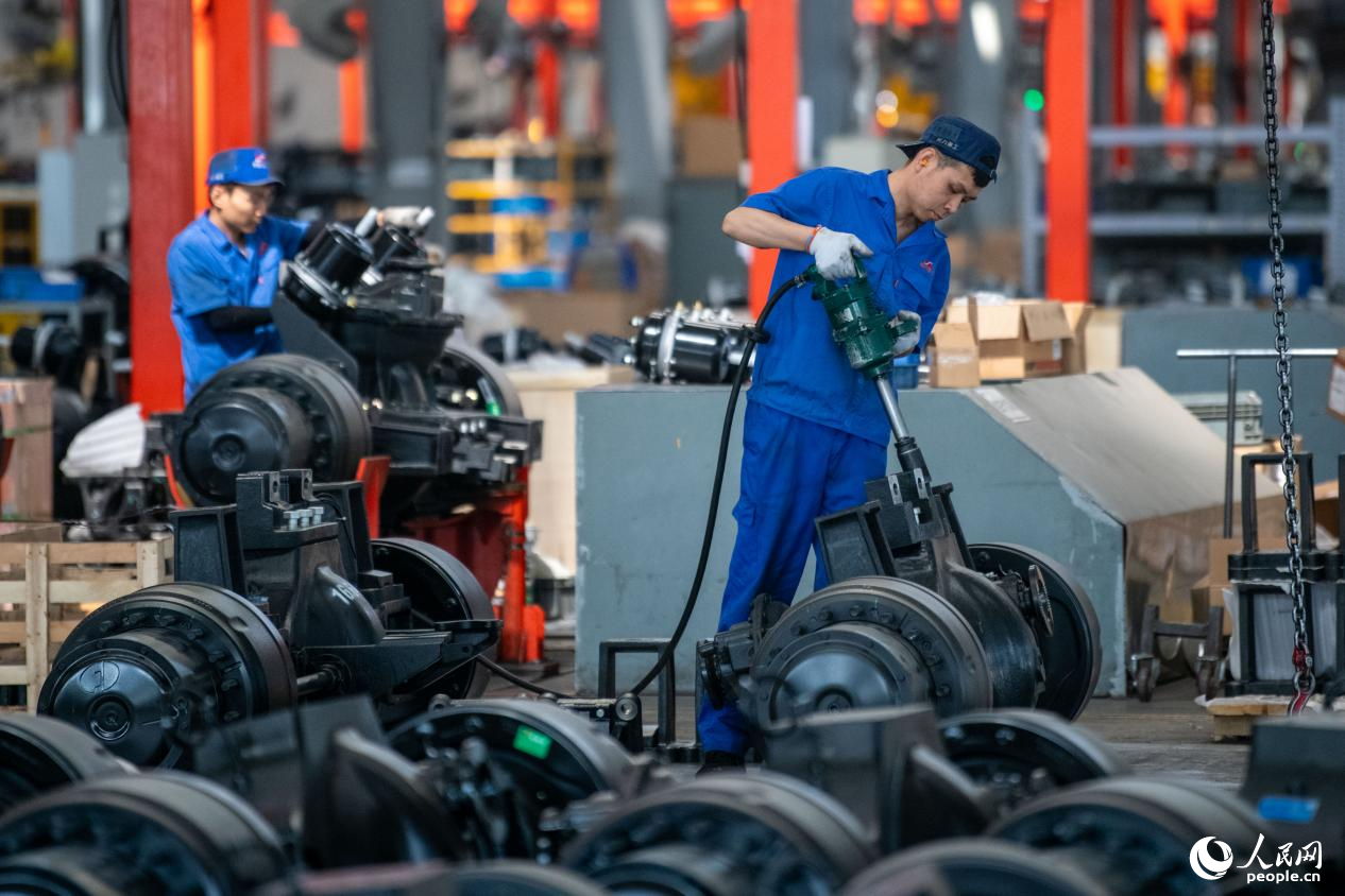 5月14日，在總裝車間，工人正在進(jìn)行非公路寬體自卸車底盤裝配作業(yè)。人民網(wǎng)記者 翁奇羽攝