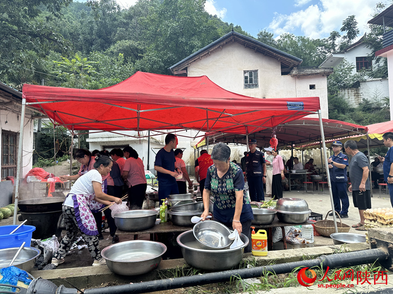 村民在應急救援服務點為救援人員做后勤保障工作。人民網(wǎng)記者 李志強攝